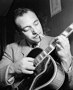 Django Reinhardt with guitar, smoking cigarette